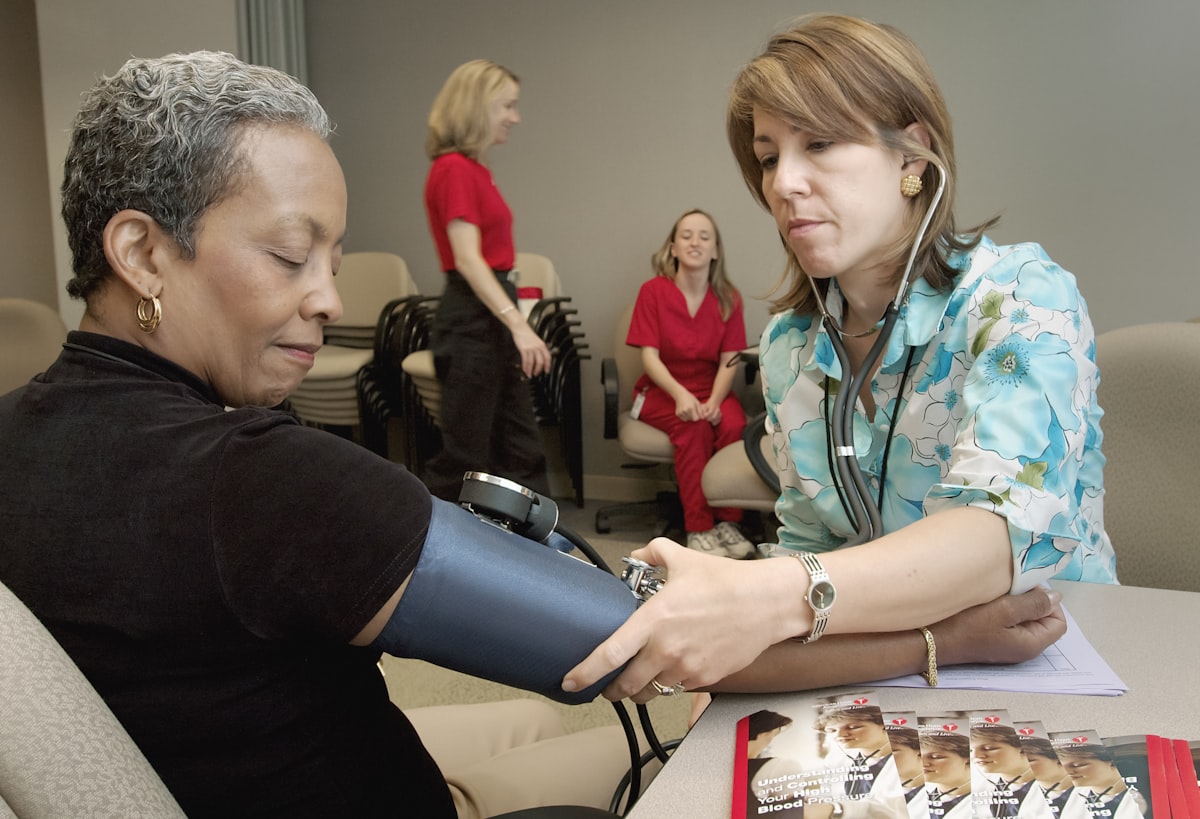 Healthcare professionals checking a patient's blood pressure